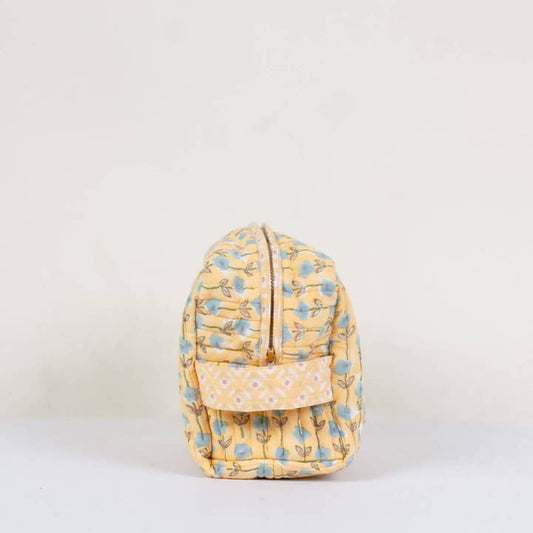 Yellow floral-patterned washbag on a light beige background