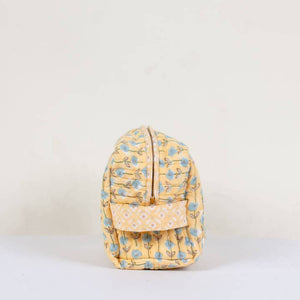 Yellow floral-patterned washbag on a light beige background