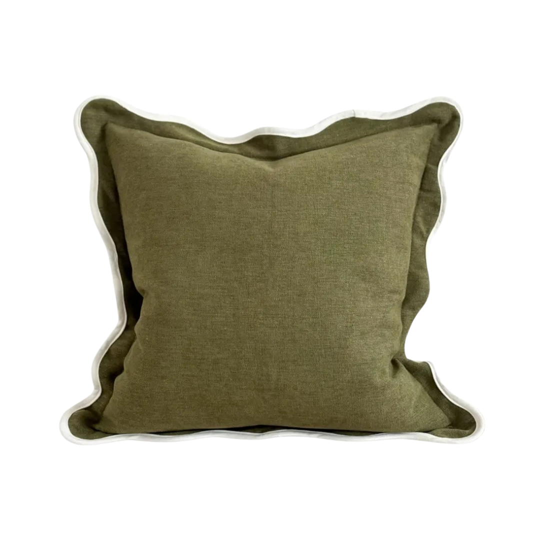 An olive green cushion with a textured linen-like fabric and a cream scalloped edge.