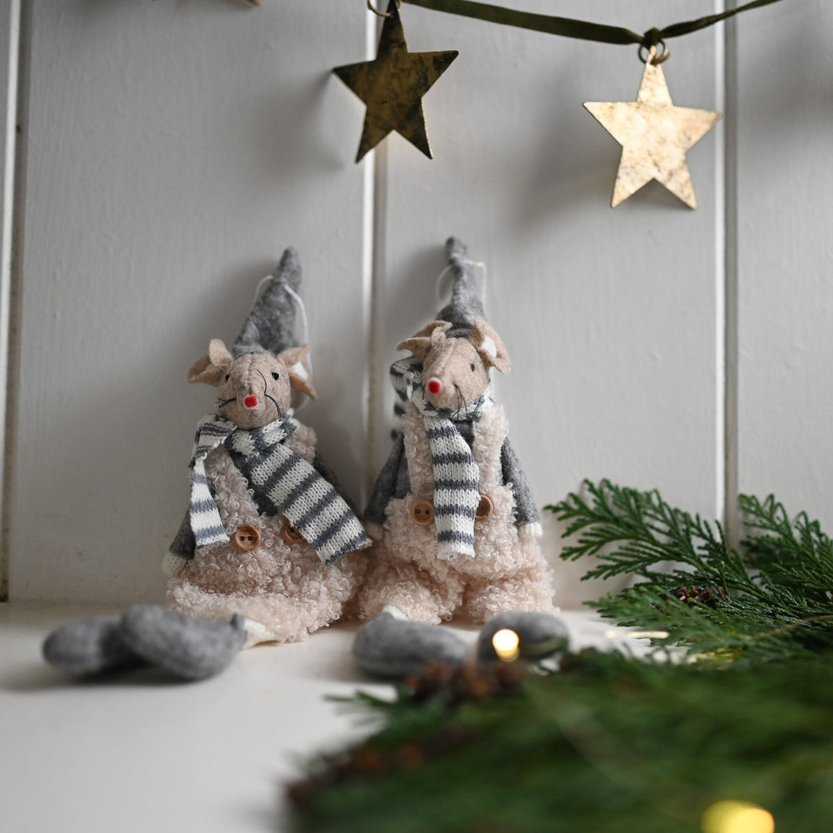 Two felt mice in winter attire with stars and lights in the background