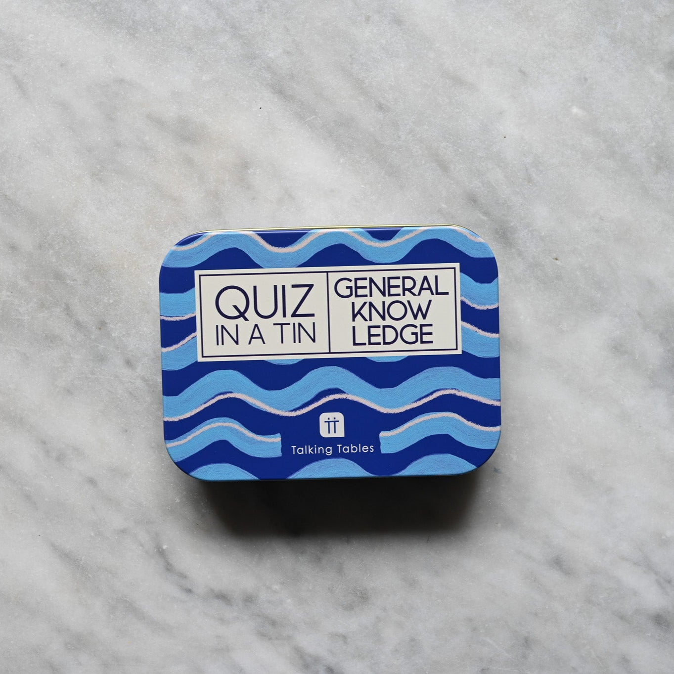 Blue tin with 'Quiz in a Tin' label on a marble surface. General Knowledge