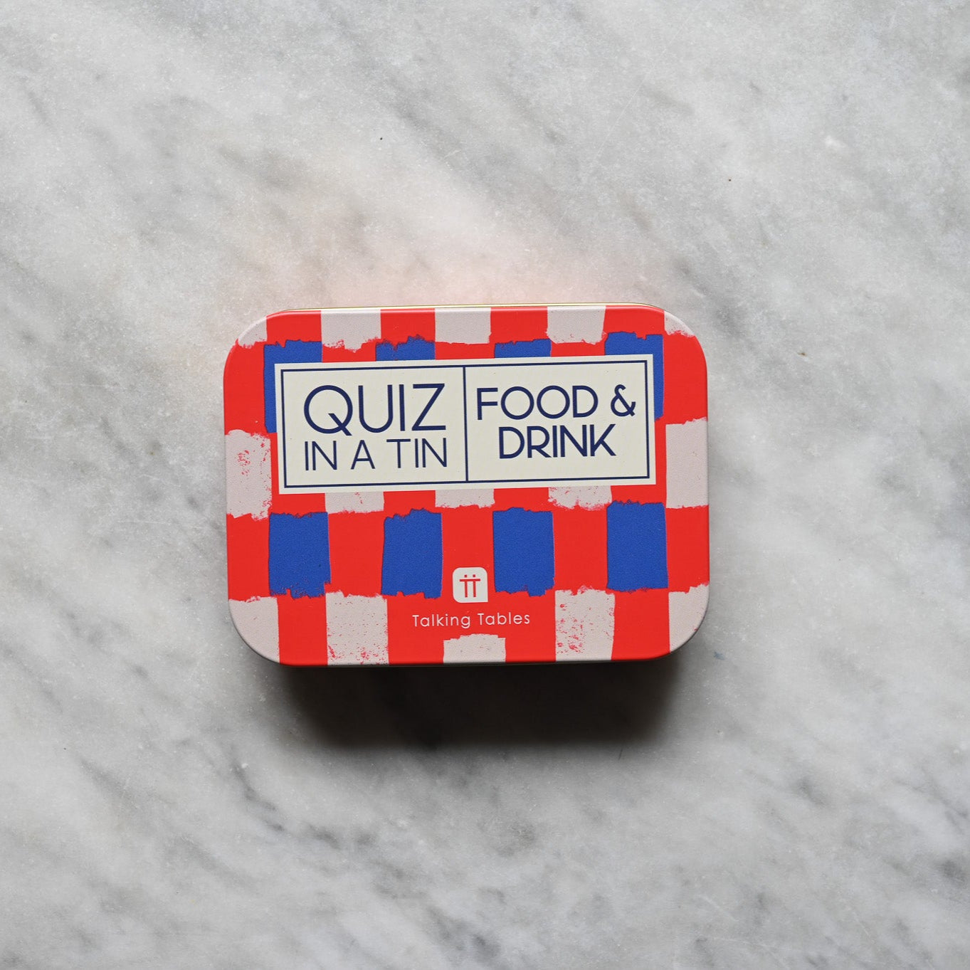 Small tin with 'Quiz in a Tin' Food & Drink label on a marble surface
