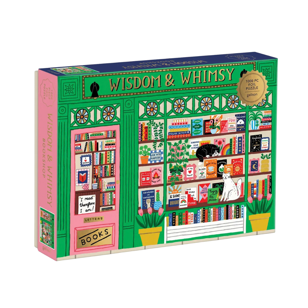 A 1000-piece jigsaw puzzle box titled 'WISDOM & WHISKY' by The Letters, featuring a colorful illustration of a bookshop window with shelves, books, plants, and cats.