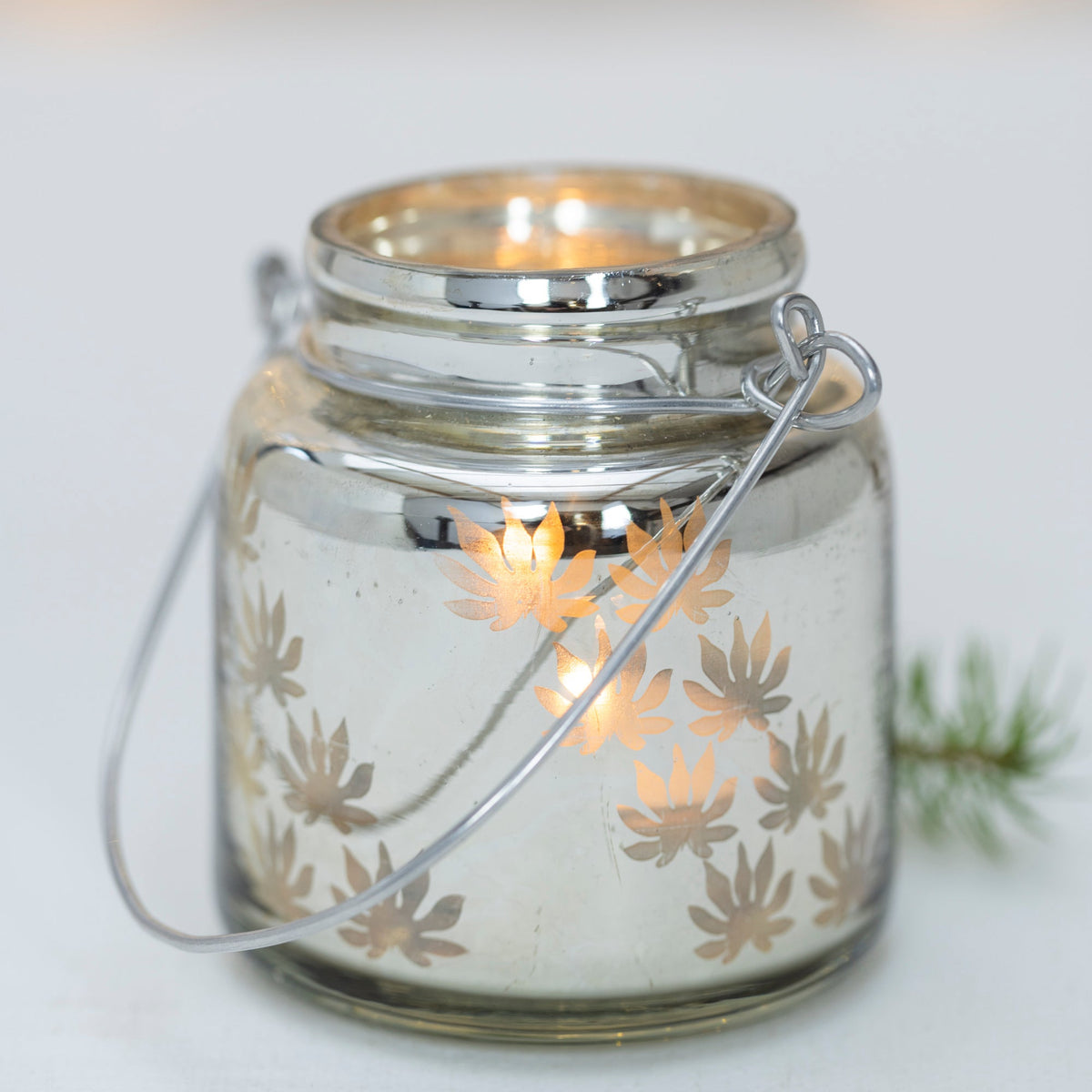 Glass jar with metal lid and decorative pattern on a white background