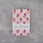Load image into Gallery viewer, Notebook with floral pattern on a gray surface
