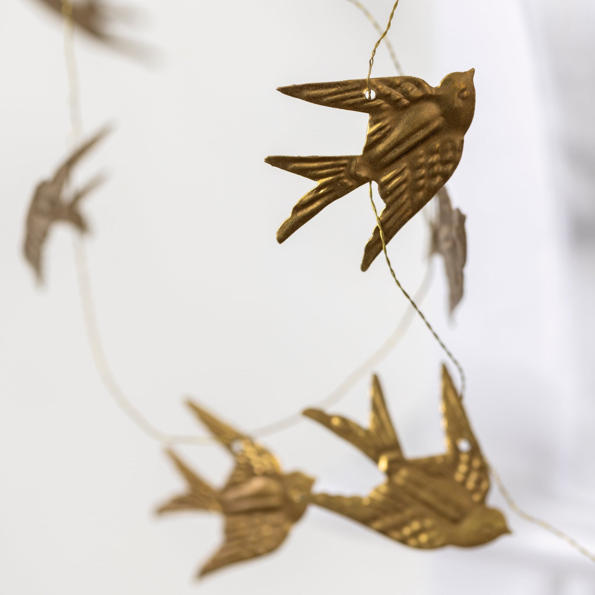 Gold bird-shaped garland on a white background