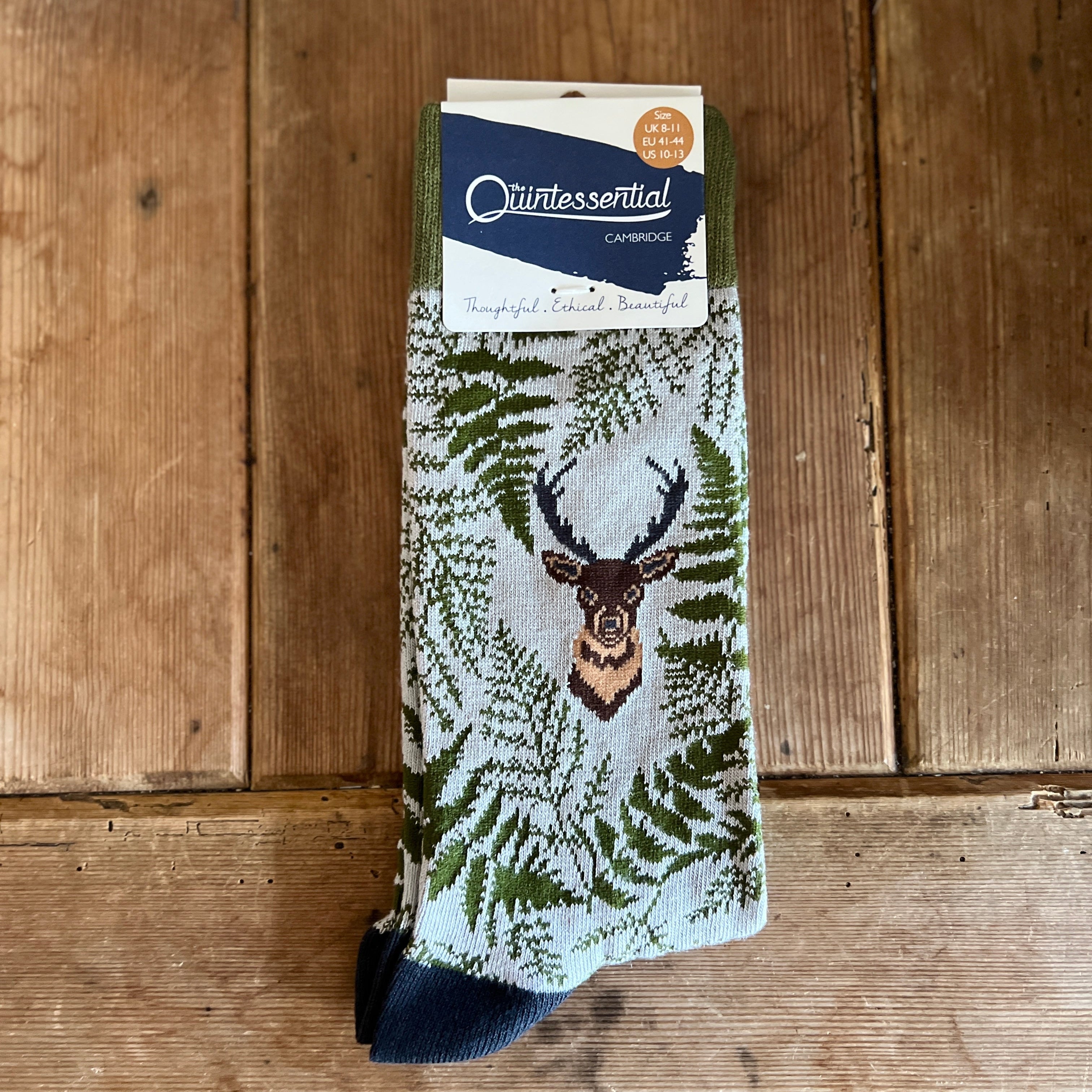 Stag and fern patterned men's sock on a wooden surface