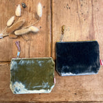 Load image into Gallery viewer, Two velvet pouches, one green and one blue, on a wooden surface with dried flowers.
