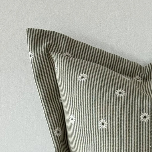 Striped cushion with floral patterns on a light gray background