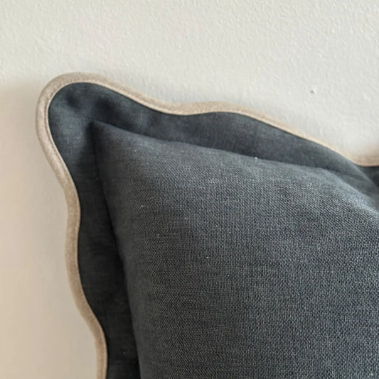 Navy cushion with cream trim on a neutral background