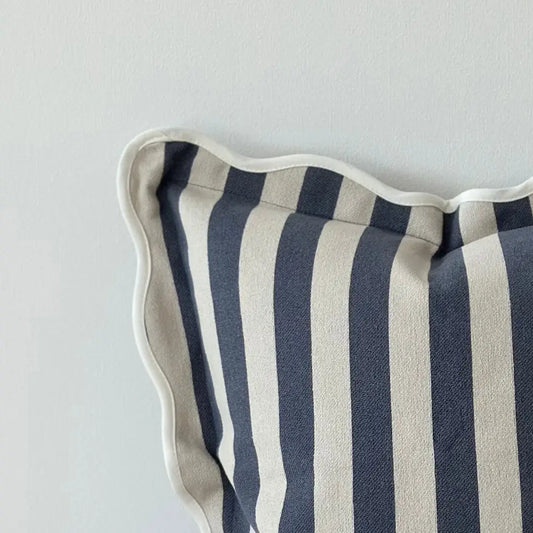 Striped cushion with blue and cream pattern on a light grey background