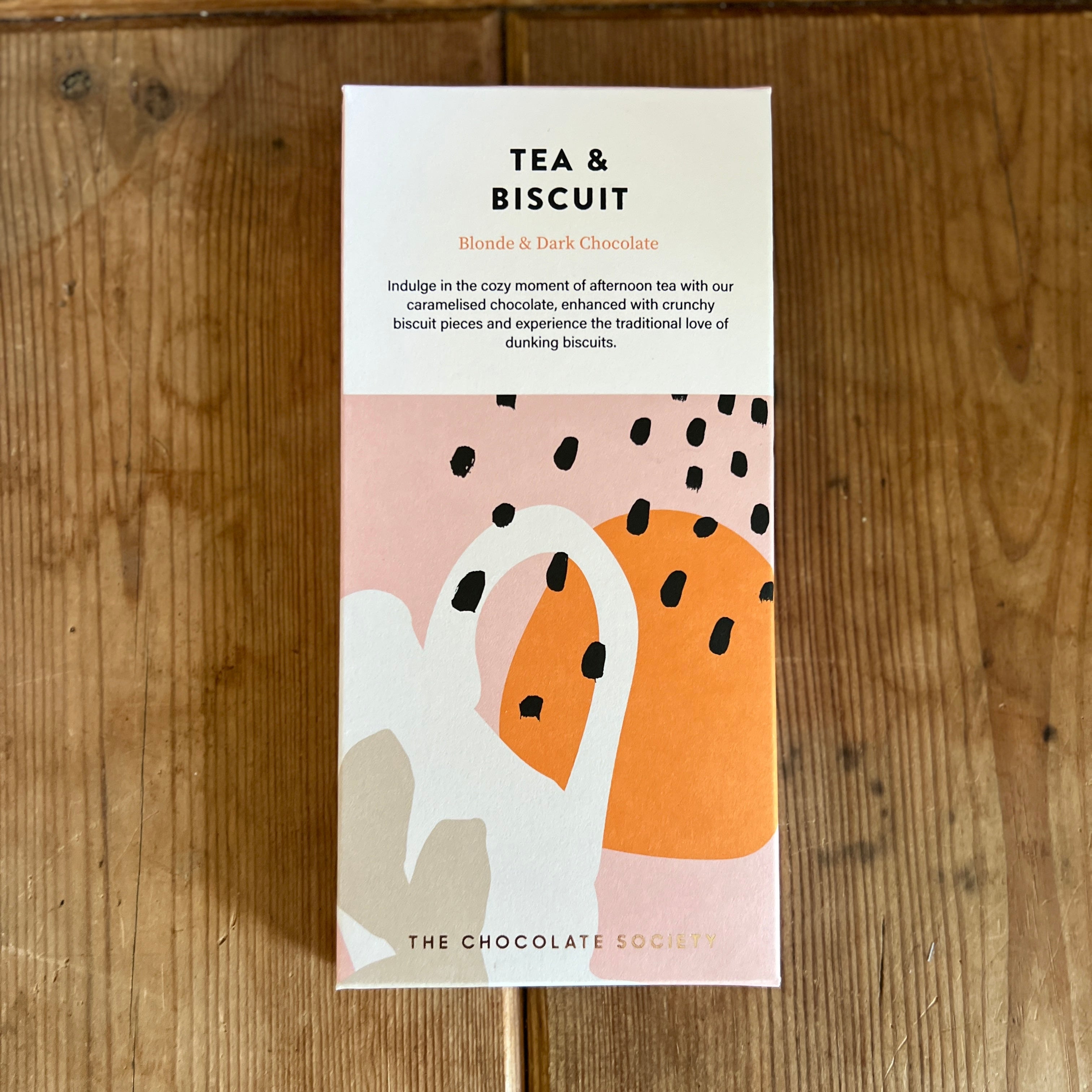 Tea and biscuit chocolate bar with abstract design on a wooden surface