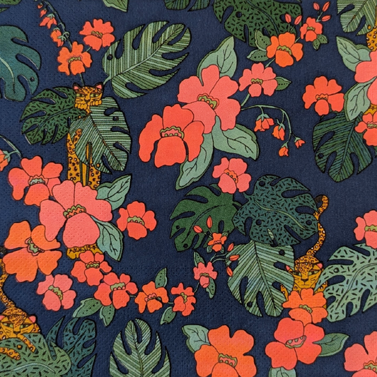 A close-up of a paper napin featuring vibrant orange hibiscus flowers, green monstera and philodendron leaves, and small orange-and-black leopard on a dark navy blue background.